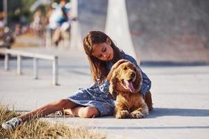 das Haustier umarmen. süßes kleines Mädchen geht an sonnigen Tagen mit ihrem Hund im Freien spazieren foto