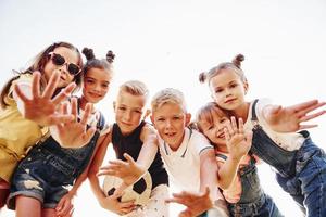 Hallo, Geste. mit Fußball. Porträt von Kindern, die zusammenstehen und für die Kamera posieren foto