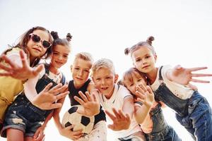 Hallo, Geste. mit Fußball. Porträt von Kindern, die zusammenstehen und für die Kamera posieren foto