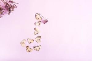 das konzept der liebe zur musik. musiknote aus papierherzen und trockenen blumen auf einem rosa. Ansicht von oben. foto