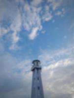 defocused abstrakt verschwommen vom weißen minarett der moschee auf der insel lombok, indonesien, auf dem hintergrund des blauen himmels mit weißen wolken. foto