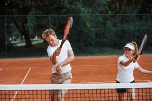 Zwei Personen in Sportuniform spielen gemeinsam Tennis auf dem Platz foto