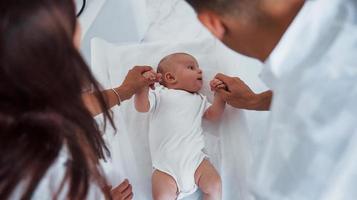 Junge Kinderärztin ist tagsüber mit kleinem Baby in der Klinik foto
