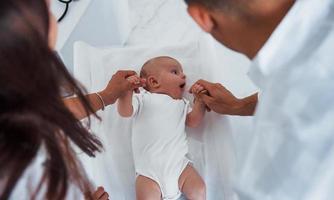 Junge Kinderärztin ist tagsüber mit kleinem Baby in der Klinik foto