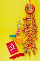 Feuerwerkskörper für das chinesische Neujahrsschmuckwort bedeutet Reichtum, Segen mit Goldbarren, orange und rotes Umschlagpaket oder ang bao-Wort bedeutet Vorzeichen auf gelbem Hintergrund. foto