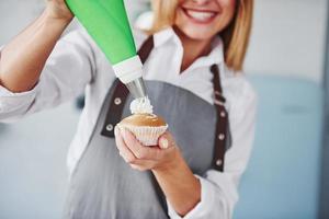 Frau steht drinnen in der Küche mit hausgemachtem Kuchen foto