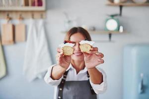 Frau steht drinnen in der Küche mit hausgemachtem Kuchen foto