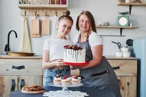 Zwei Frauen bereiten gemeinsam leckere Süßigkeiten in der Küche zu foto