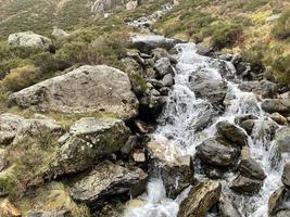 Szenische Darstellung von Wasser, das in einem Mini-Wasserfall in Schottland Felsen hinunterstürzt foto