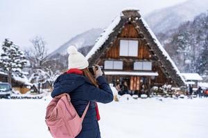 junge reisende, die im winter mit schnee in shirakawa-go genießt foto