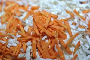 geschredderter Weißkohl mit geriebenen Karotten in einem Becken foto