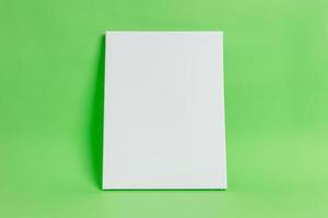 weiße Kunstleinwand auf grüner Oberfläche. saubere, leere oberfläche für modell, kunstpräsentation. Kunstvorlage foto