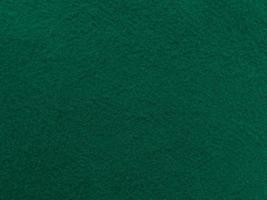 Filz dunkelgrün weiches raues Textilmaterial Hintergrundtextur Nahaufnahme, Pokertisch, Tennisball, Tischdecke. leerer neuer Stoffhintergrund. foto