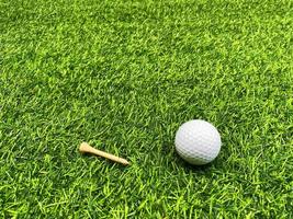 golfball nah oben auf grünem gras auf unscharfer schöner landschaft des golfhintergrundes.konzept internationaler sport, der auf präzisionsfähigkeiten zur gesundheitsentspannung angewiesen ist.