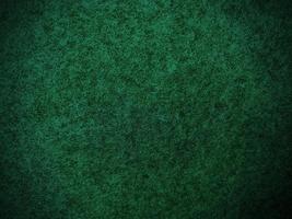 Filz dunkelgrün weiches raues Textilmaterial Hintergrundtextur Nahaufnahme, Pokertisch, Tennisball, Tischdecke. leerer grüner Stoffhintergrund. foto