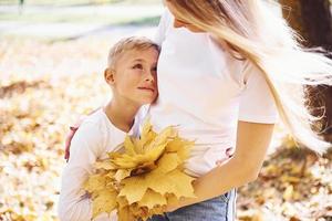 mutter mit sohn erholen sich an einem sonnigen tag in einem schönen herbstpark foto