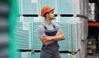 porträt eines jungen arbeiters in uniform, der sich im lager befindet foto