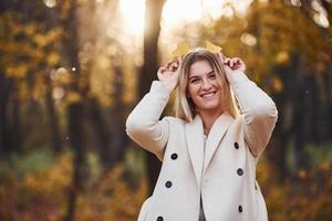 porträt einer jungen brünetten, die tagsüber spaß im herbstwald hat foto