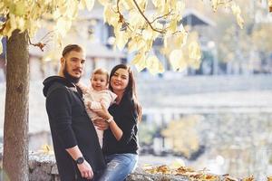 Fröhliche Familie geht zusammen mit ihrem Kind im Park spazieren foto