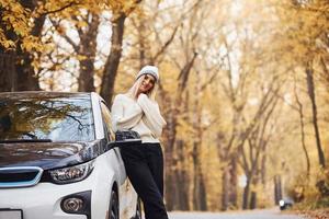 Mädchen haben Herbstausflug mit dem Auto. modernes, brandneues Auto im Wald foto