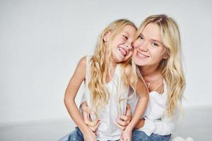 Nähe der Menschen. Mutter mit ihrer Tochter zusammen im Studio mit weißem Hintergrund foto