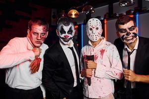 Freunde ist auf der thematischen Halloween-Party in gruseligem Make-up und Kostümen foto