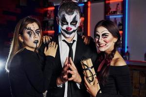 Freunde ist auf der thematischen Halloween-Party in gruseligem Make-up und Kostümen foto