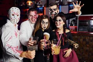 für die Kamera posieren. Freunde ist auf der thematischen Halloween-Party in gruseligem Make-up und Kostümen foto
