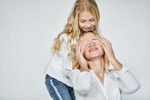 mutter mit ihrer tochter haben gemeinsam spaß im studio mit weißem hintergrund foto