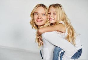 mutter mit ihrer tochter haben gemeinsam spaß im studio mit weißem hintergrund foto