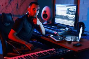 Typ hat einen Job mit Projekt und mischt Musik drinnen im Studio foto