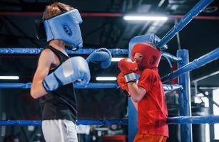 zwei jungen in schutzausrüstung haben sparring und kämpfen auf dem boxring foto