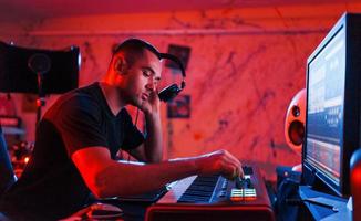 professioneller toningenieur, der musik drinnen im studio bearbeitet und mischt foto