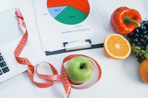 Früchte liegen mit Maßband auf dem Tisch. Konzeption des Gesundheitswesens foto