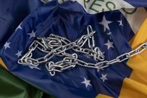 Kette und brasilianische Flagge symbolisieren die Sklaverei im Land foto