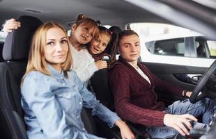 Fröhliche Familie, die zusammen in einem Auto fährt. viel spass und schönes wochenende foto