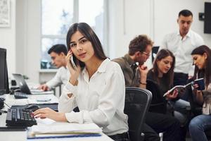 Frau hat einen Anruf. junge geschäftsleute, die im modernen büro zusammenarbeiten foto