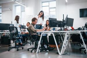 Gruppe junger Geschäftsleute, die im modernen Büro am Computer arbeiten foto