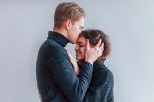Süßes junges Paar, das sich drinnen im Studio umarmt foto