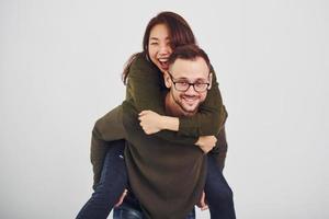 glückliches multiethnisches paar in lässiger kleidung hat drinnen im studio spaß zusammen. Kaukasier mit asiatischer Freundin foto