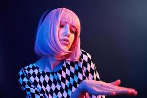 Porträt eines jungen Mädchens mit blonden Haaren in rotem und blauem Neon im Studio foto