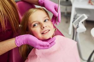 kleines mädchen, das zahnarzt in der klinik besucht. Konzeption der Stomatologie foto