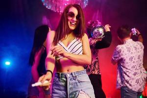 junge leute haben spaß im nachtclub mit bunten laserlichtern foto