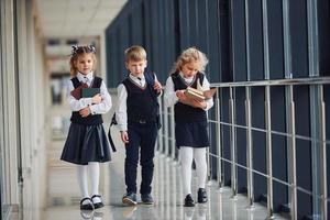 Schulkinder in Uniform zusammen im Korridor. Konzeption von Bildung foto