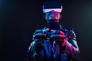 Virtual-Reality-Erfahrung. futuristische neonbeleuchtung. junger Afroamerikaner im Studio foto