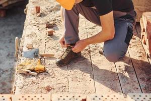 Nahaufnahme des Bauarbeiters in Uniform und Sicherheitsausrüstung, die sich auf den Job vorbereiten foto