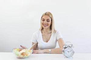 Zeit zum Abnehmen, Essenskontrolle oder Zeit zum Diätkonzept. retro-wecker, in dem frau intermittierendes fasten mit einem gesunden salatessen macht. foto