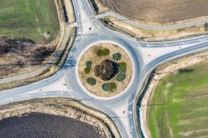 Kreisstraße europäischer Kreisverkehr mit wenig Autoverkehr, Radweg und landwirtschaftlichen Feldern. Straßen mit Kreisverkehr für besseren Transport foto