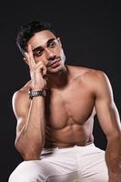 hübsches arabisches männliches Model mit perfektem Körper posiert im Studio. Porträt eines athletischen männlichen Modells, das auf dunklem Hintergrund im Studio posiert. Modekonzept. foto