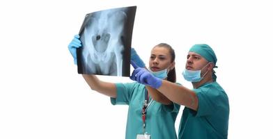 weibliche radiologen und männlicher arzt, der die röntgenaufnahme des patienten überprüft. isoliert auf weißem Hintergrund foto